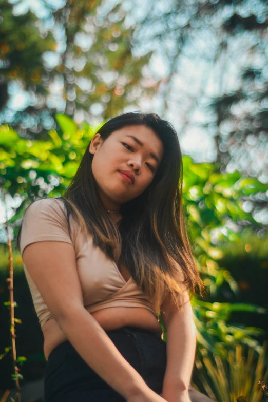 an asian girl poses for the camera while in a garden