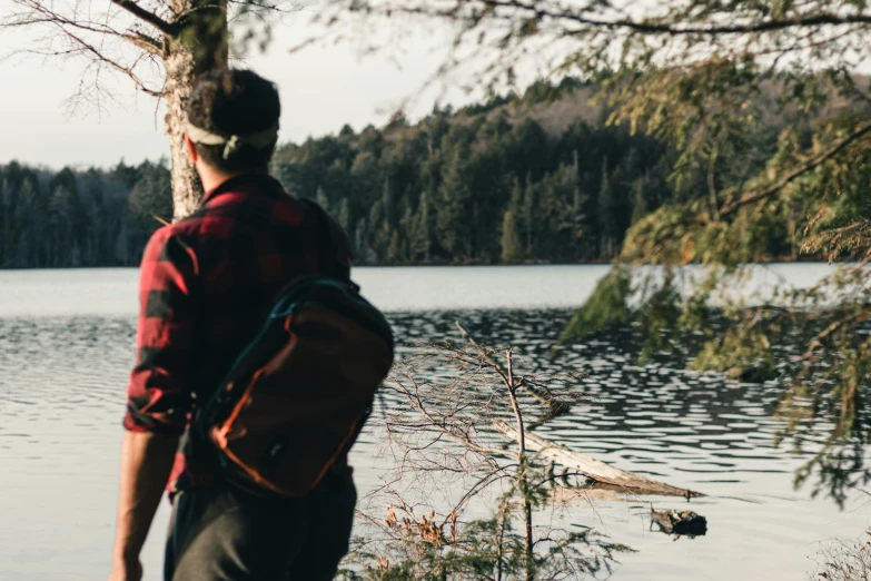 a person with a backpack looking out on a lake