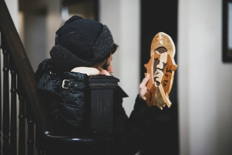 a  standing on steps holds up a shoe