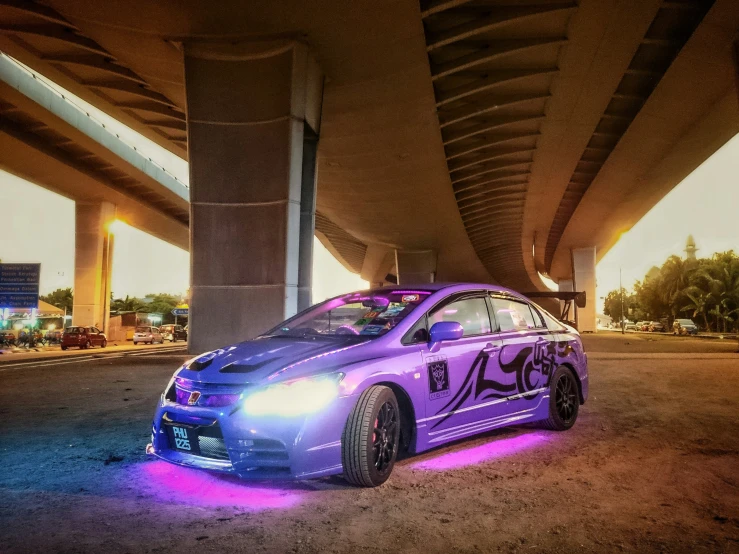 a purple car with purple graffiti parked on the road