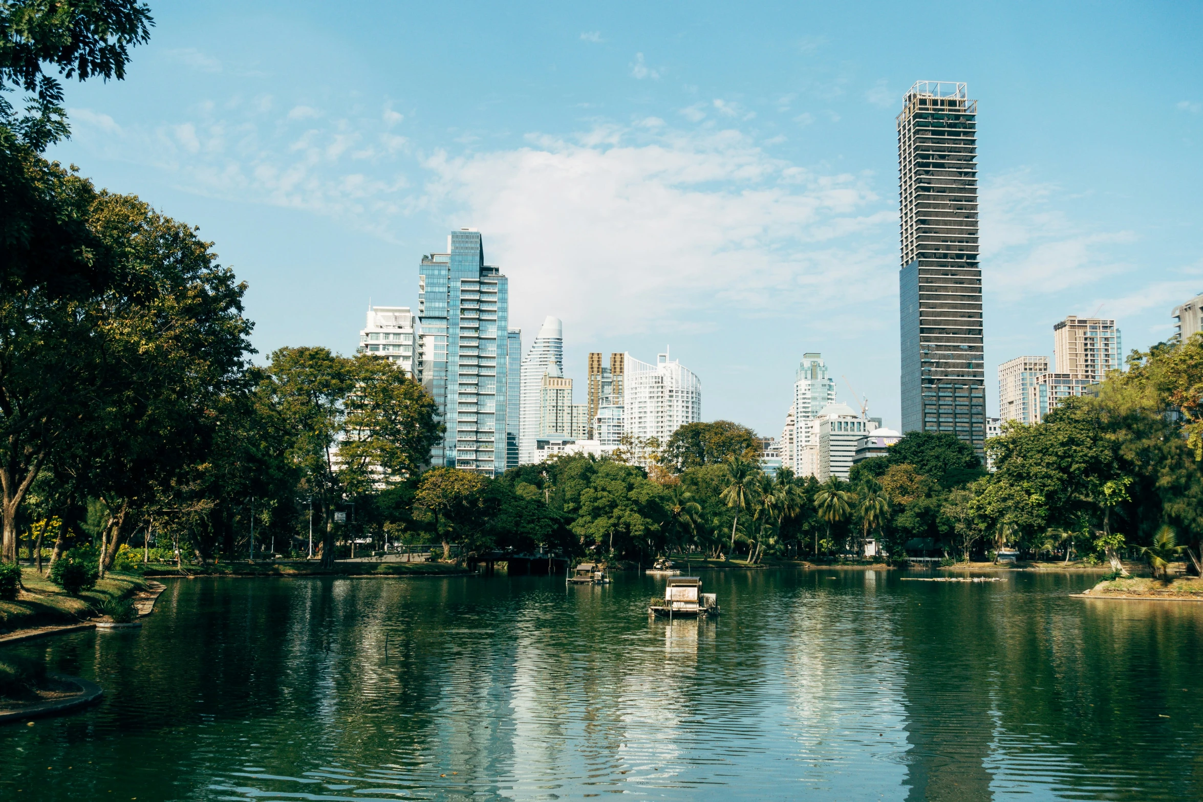 boats in the middle of the river with a city skyline in the background