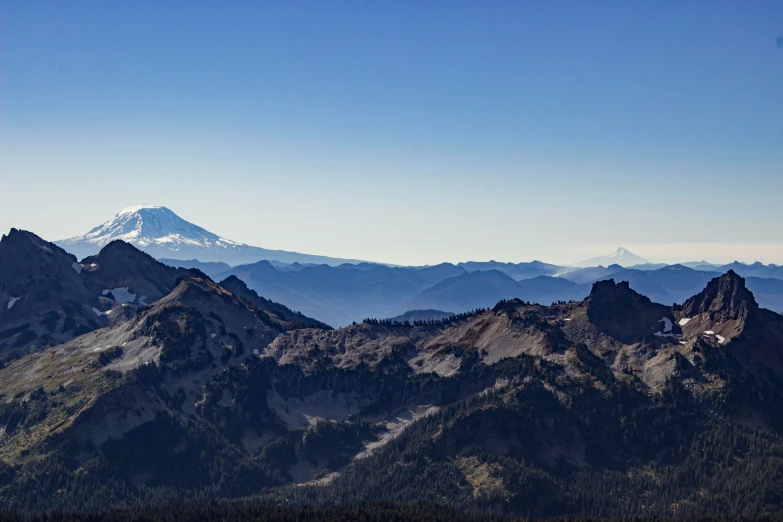 a mountain range with snow and some mountains in the background