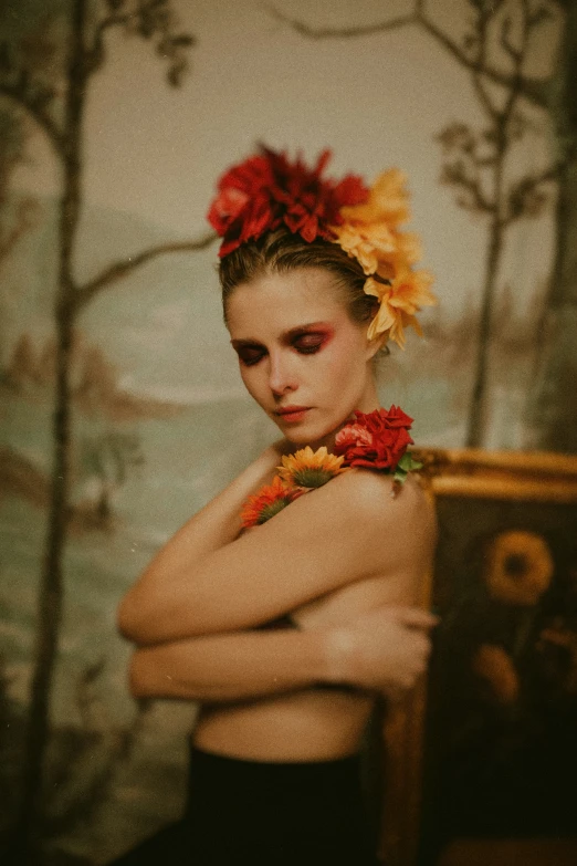 a woman with flowers in her hair and a flower in her hair is posing against a wall