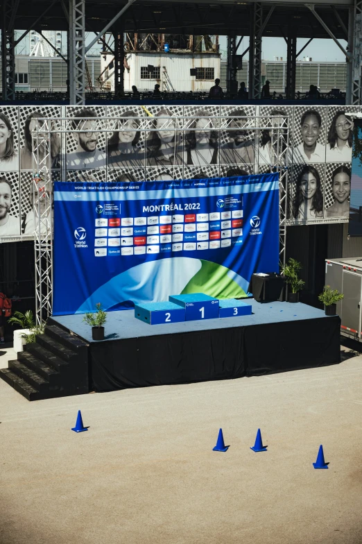 a stage with several signs on it that are surrounded by blue cones