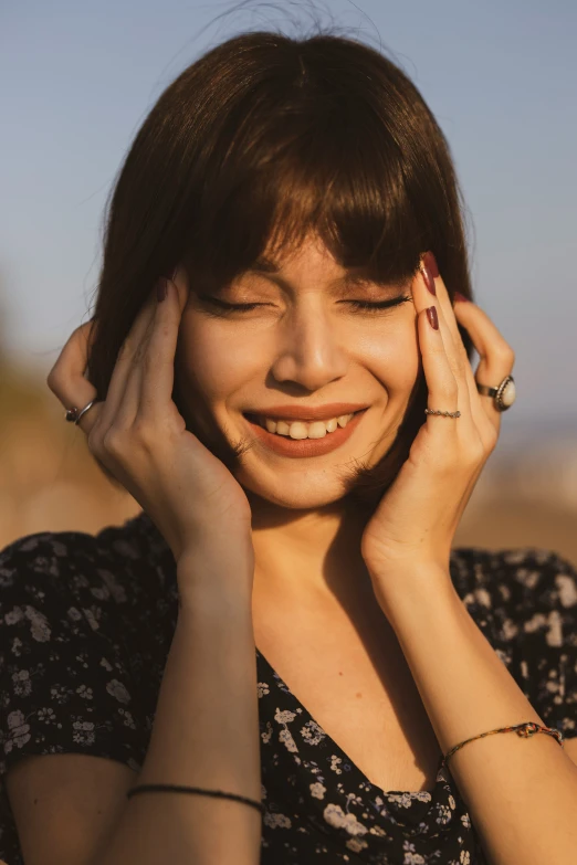 a woman with bangs, brown hair and wearing rings