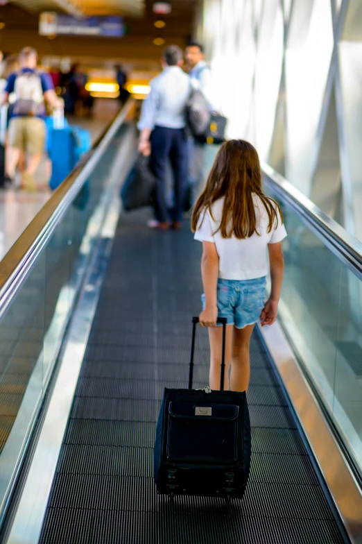 a  holding onto a piece of black luggage