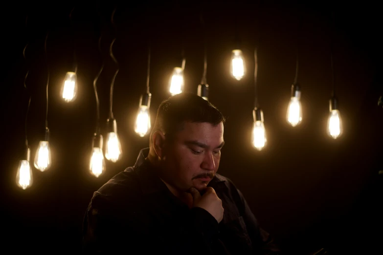 a man is sitting in front of many lights