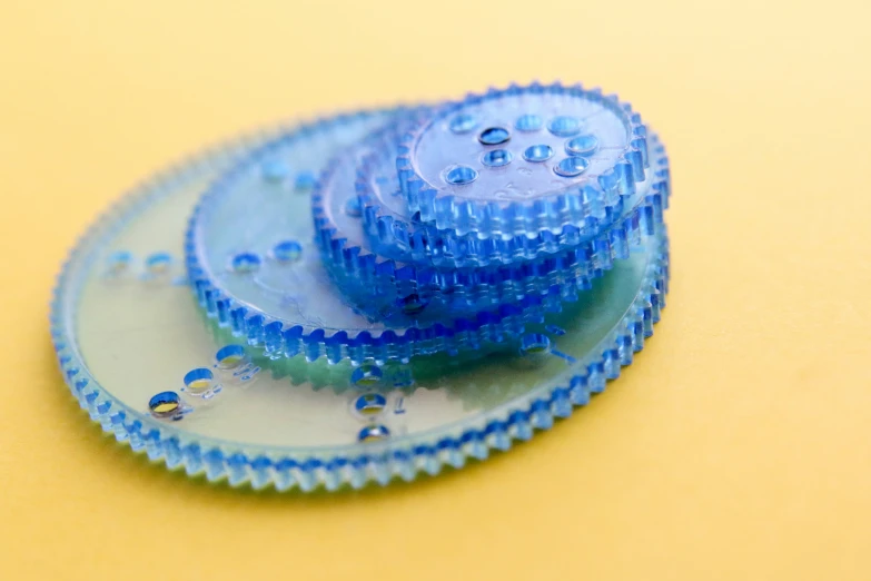 three plastic, blue objects in the shape of gears