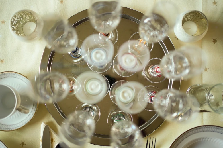 an arrangement of wine glasses and silverware on top of a table