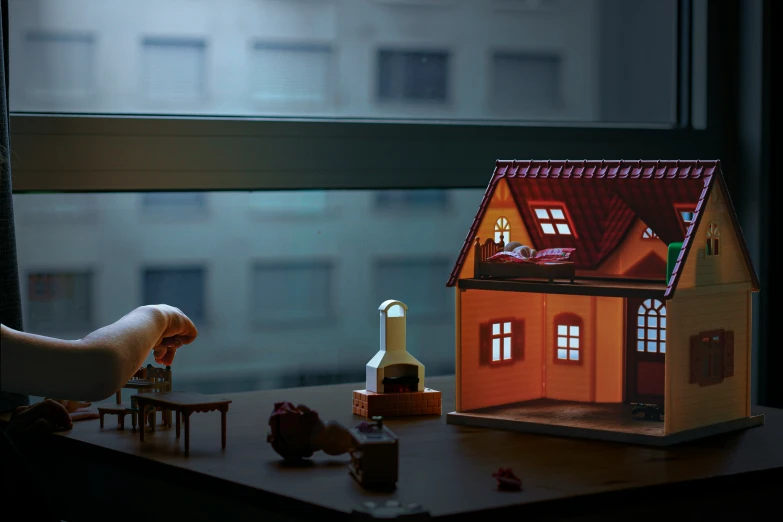 a doll house on top of a table next to other dolls and toys