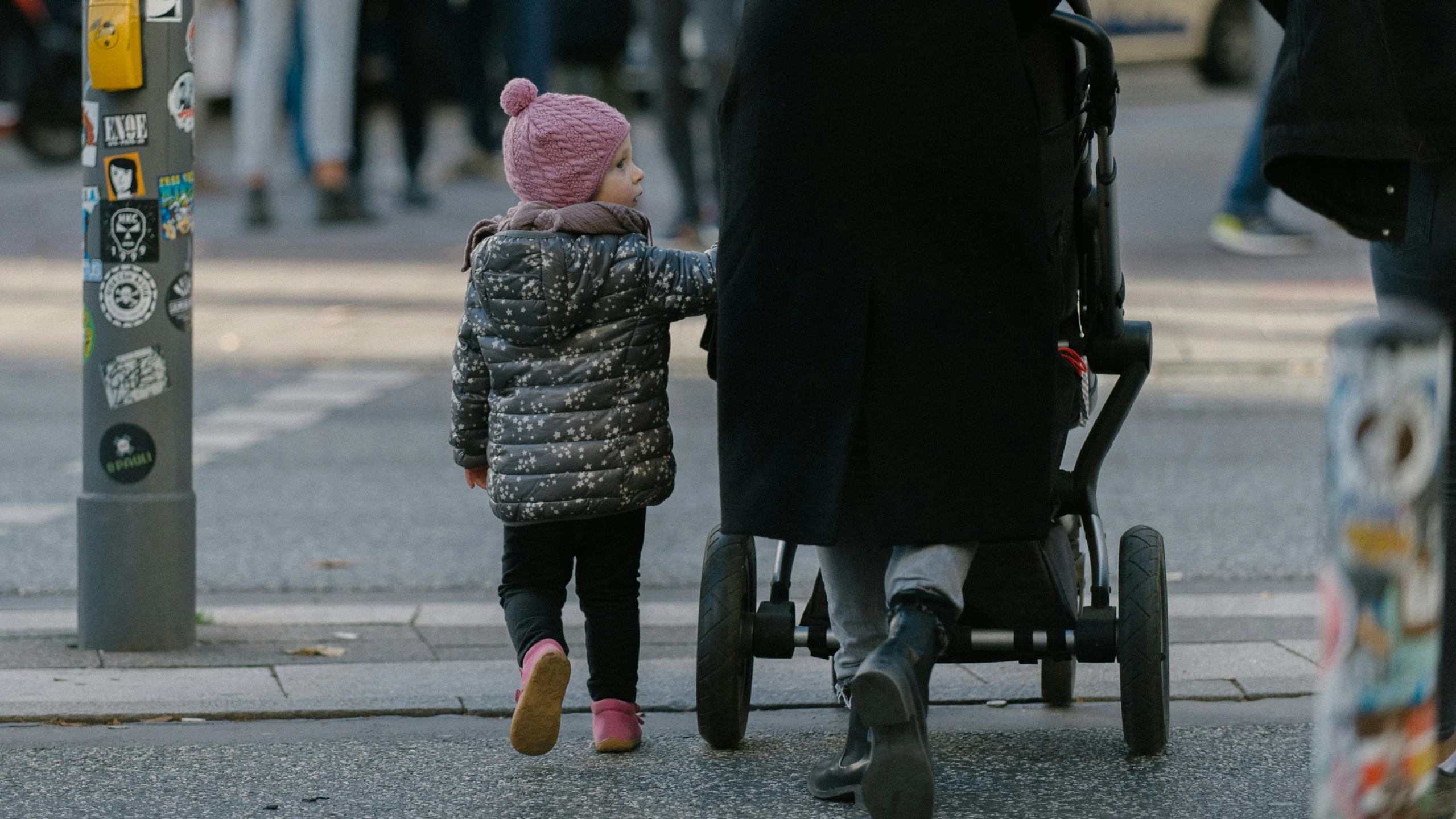 a woman with her baby standing next to a stroller