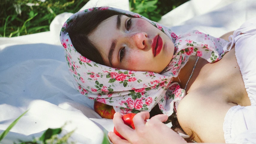 a  wearing a flower print wrap is laying in the sun