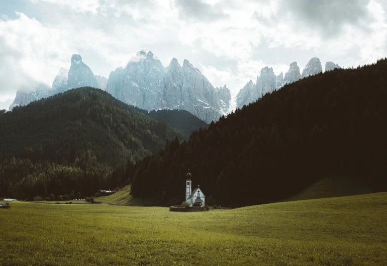 a lone church stands amongst some mountains