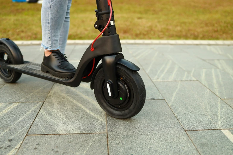 someone in black shoes on a black scooter