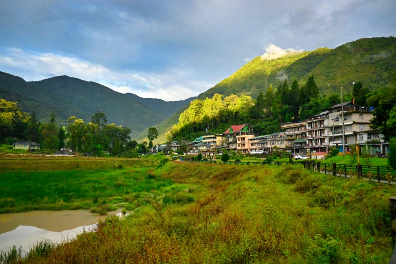 a beautiful countryside with homes on the edge and mountains in the background