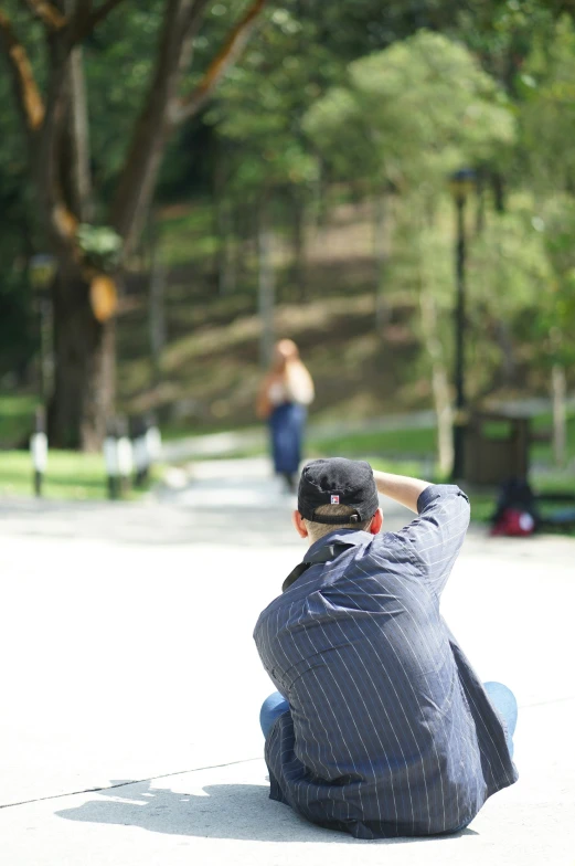 a man sitting on the floor in a park