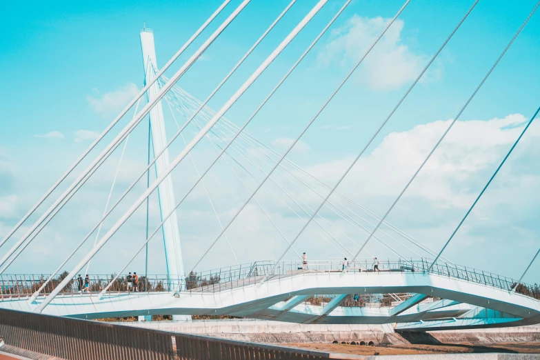 people walking on a bridge going over a river