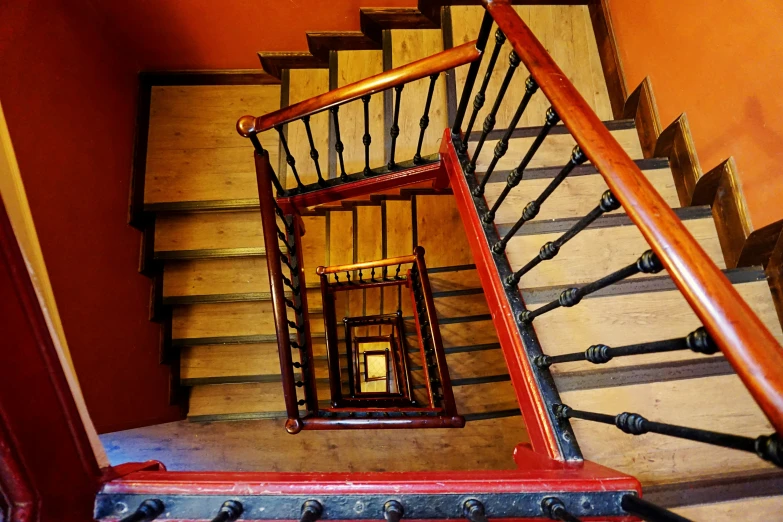 a stair railing that extends to a very small area where a man walks