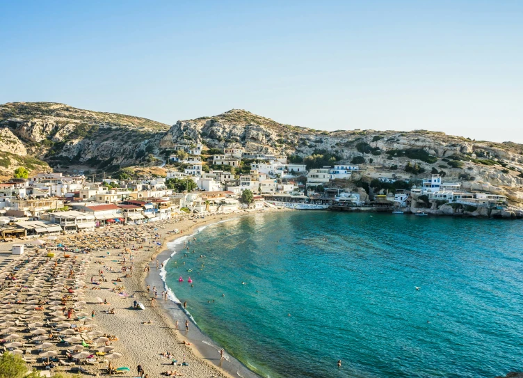 a bunch of people are on a beach by the ocean