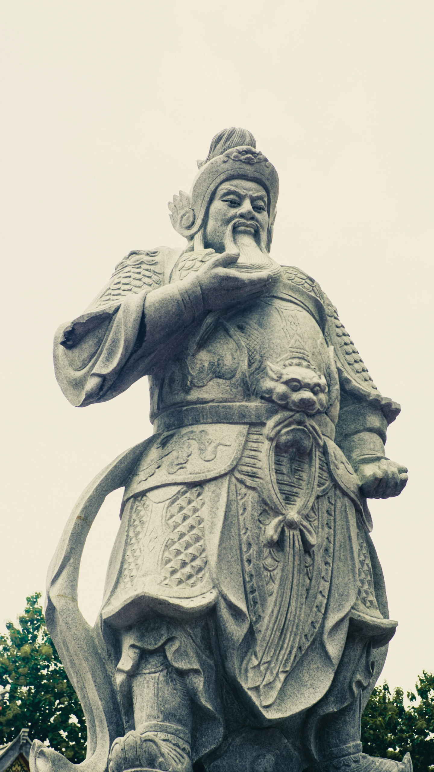 a stone statue of an asian man is holding a bow