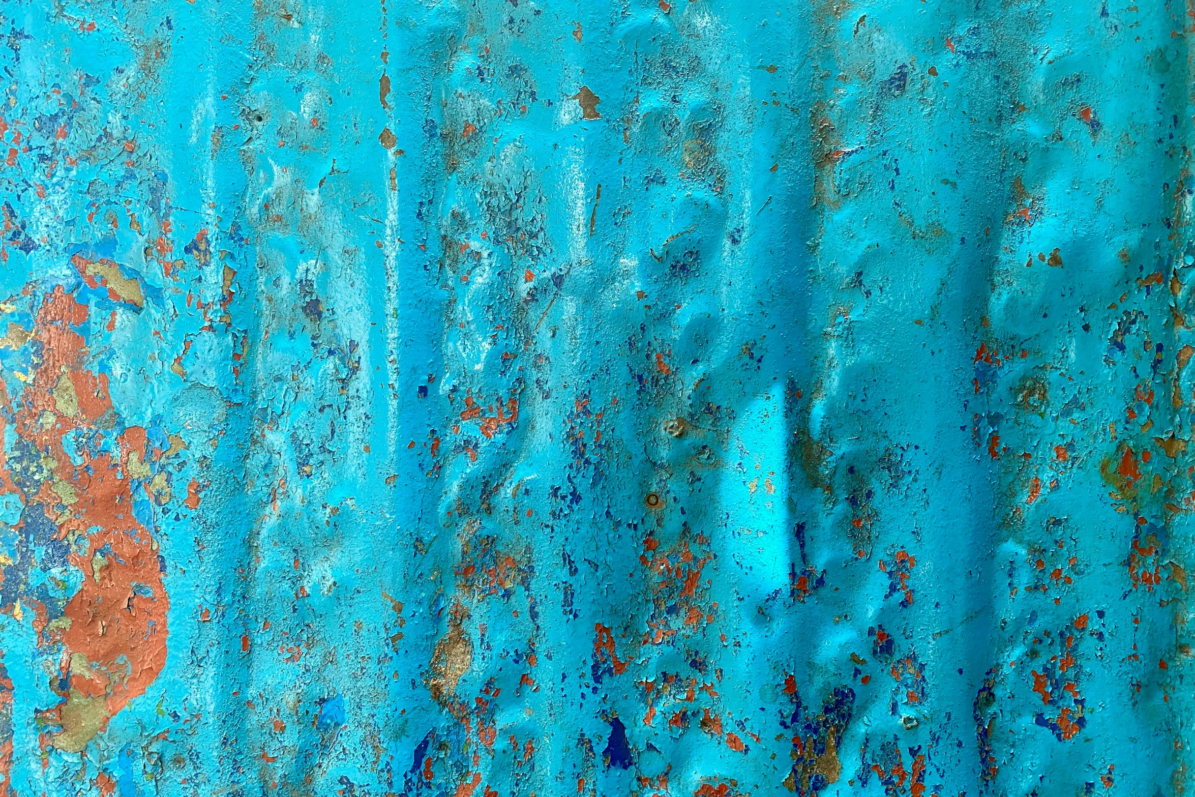 a blue curtain with rusted orange paint on it