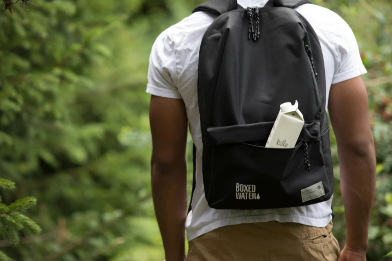 a person with a backpack on, walking through trees