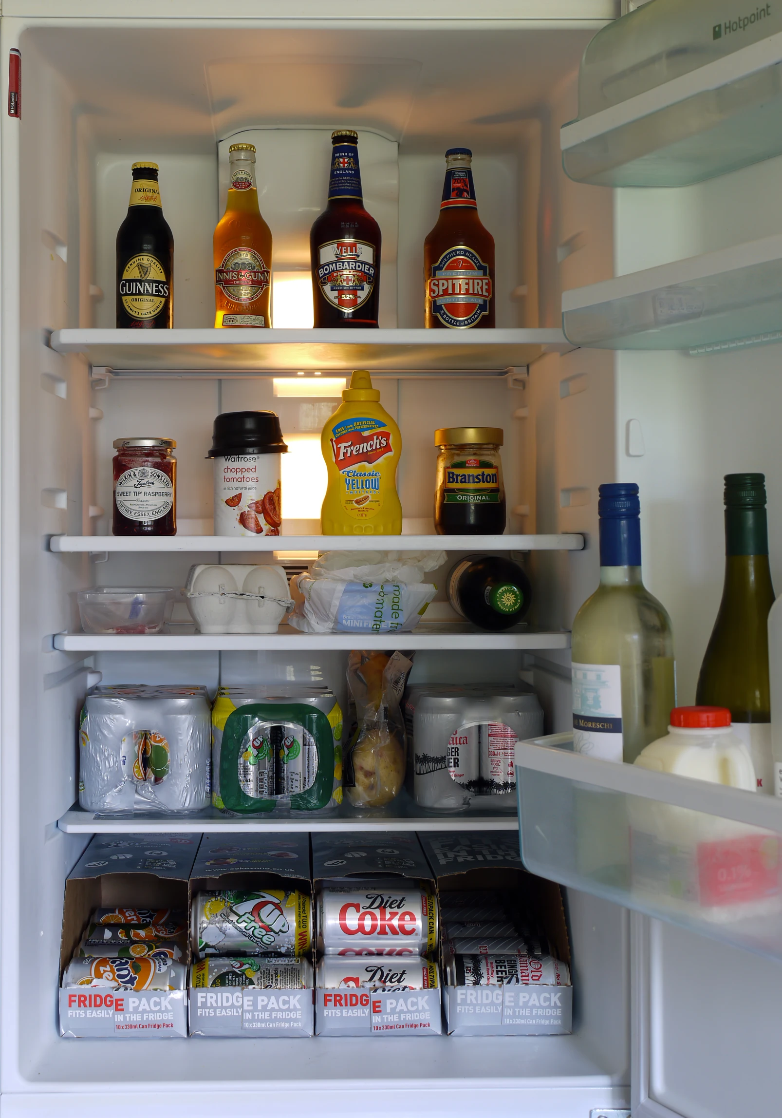 a refrigerator with many condiments, drinks and condiments