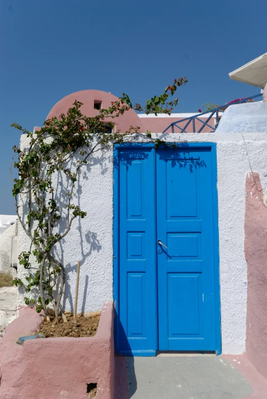 a bright blue door sits in the middle of the stucco facade