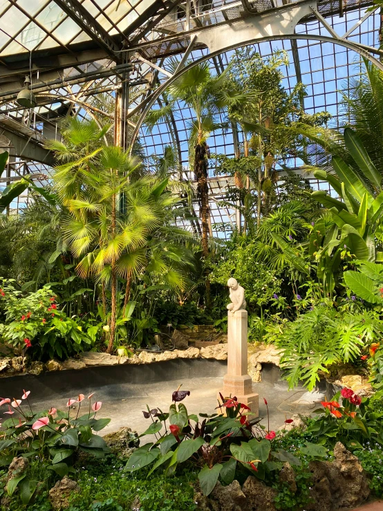 an area with many flowers and trees inside a glass house