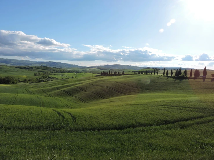 a lush green field surrounded by hills