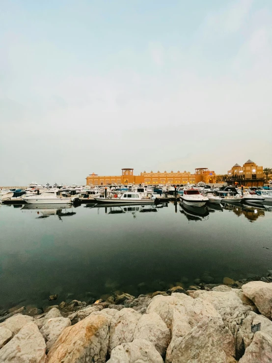 boats and yachts in water next to rocks