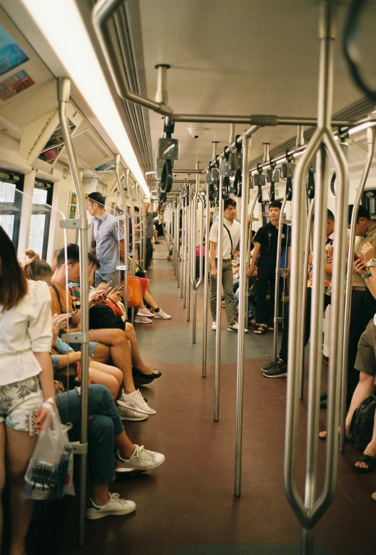 many people sit on a commuter train and wait for their bus