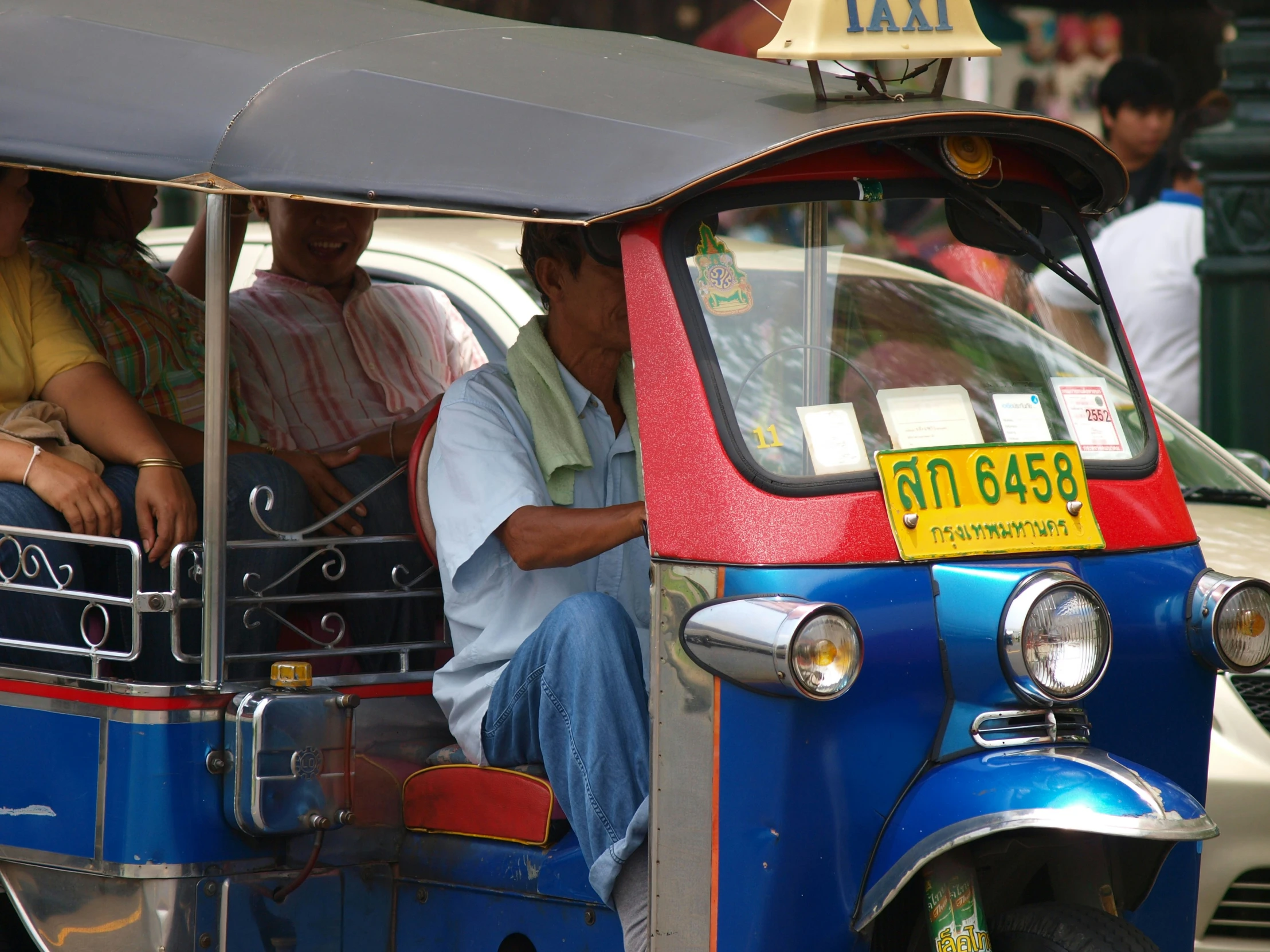 several people sit in the driver of a tuk - tuk