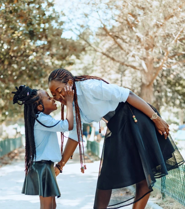 the two females are sharing a tender moment in their public park