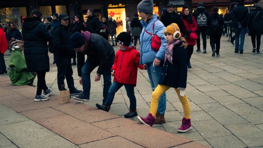 a group of people walking down the street with luggage