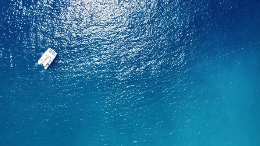 a single boat sitting in the blue water