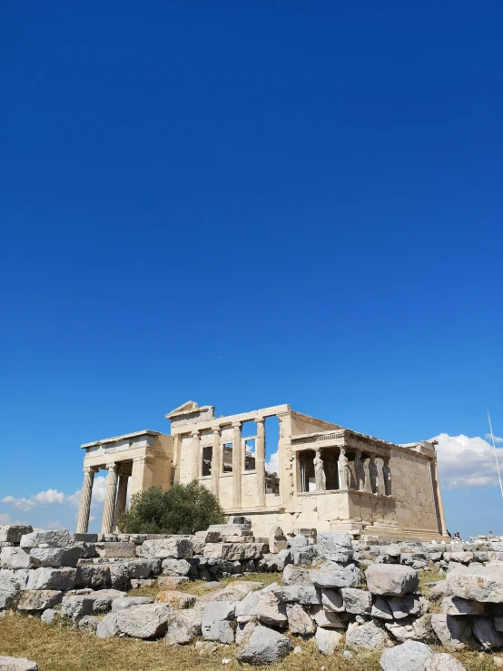 the ruins of an old building sit among huge rocks