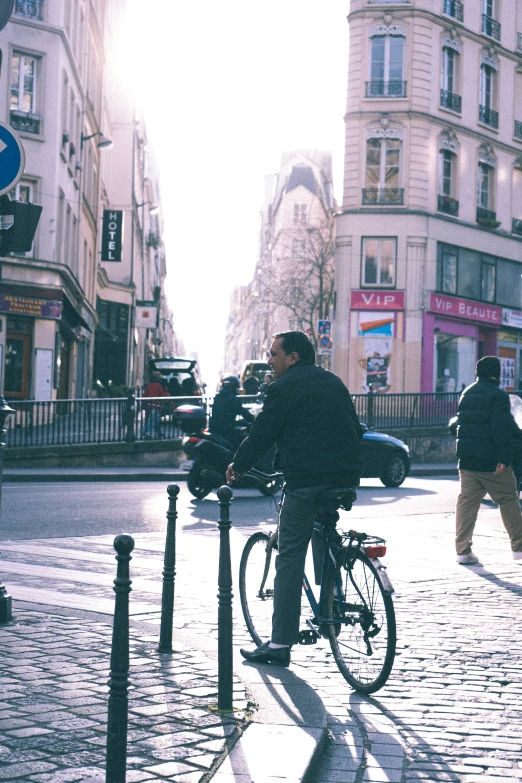 a man on a bike crossing a city street