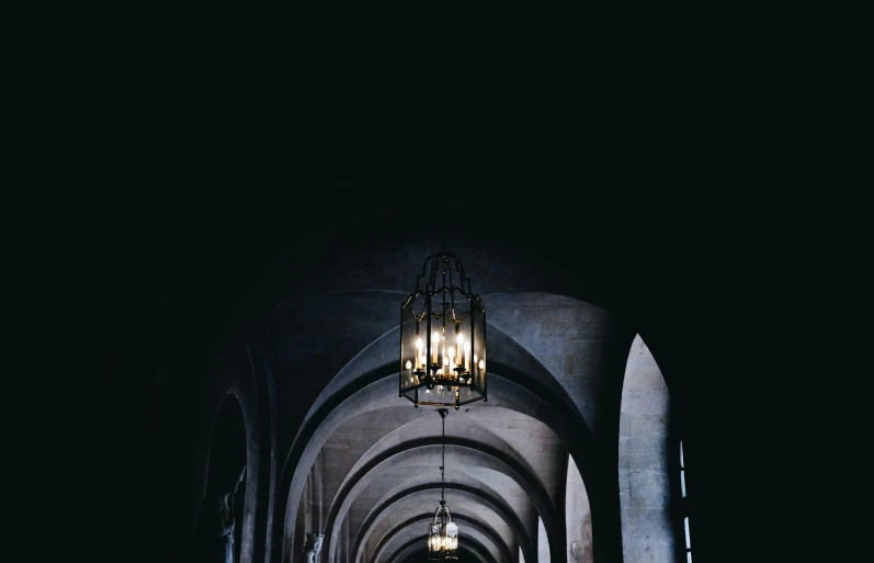 a dark cathedral is lit by a chandelier