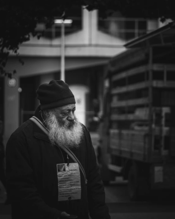 a man with long beard standing outside a truck