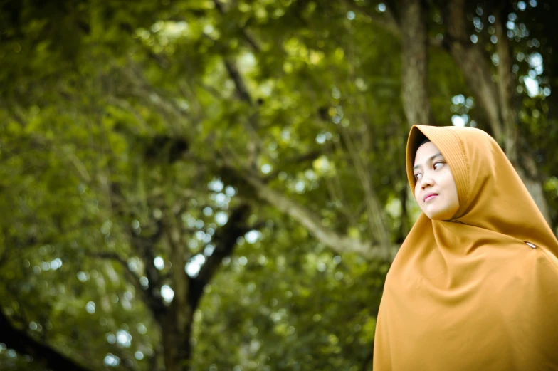 a woman is dressed in a yellow dress outside