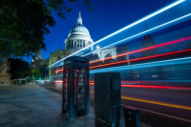 two telephone booths sitting on the side of a road