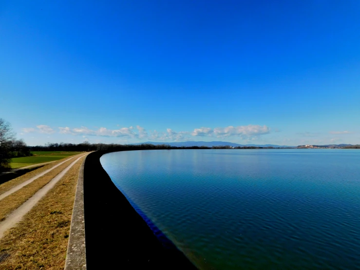 a large body of water sitting under a blue sky