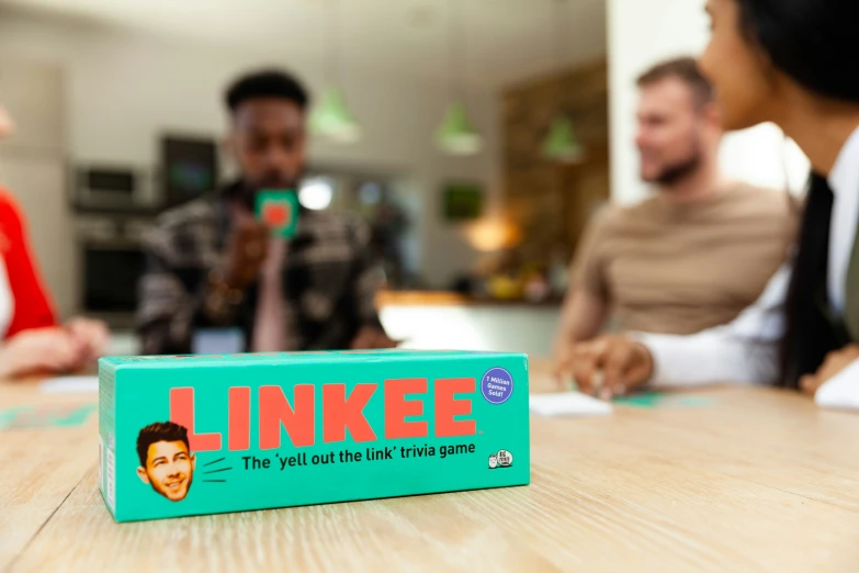 a board game sits on a table as people look around