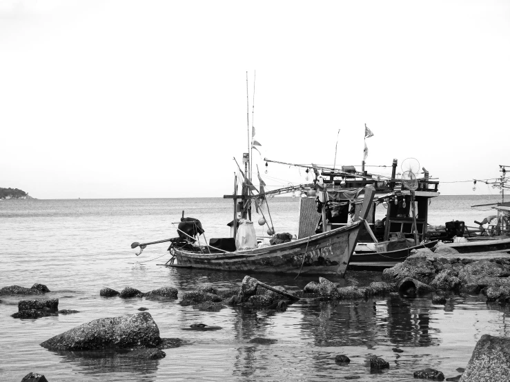 a black and white po of three fishing boats on a beach