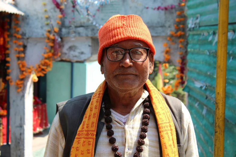 a man wearing a bright orange hat and wearing beads