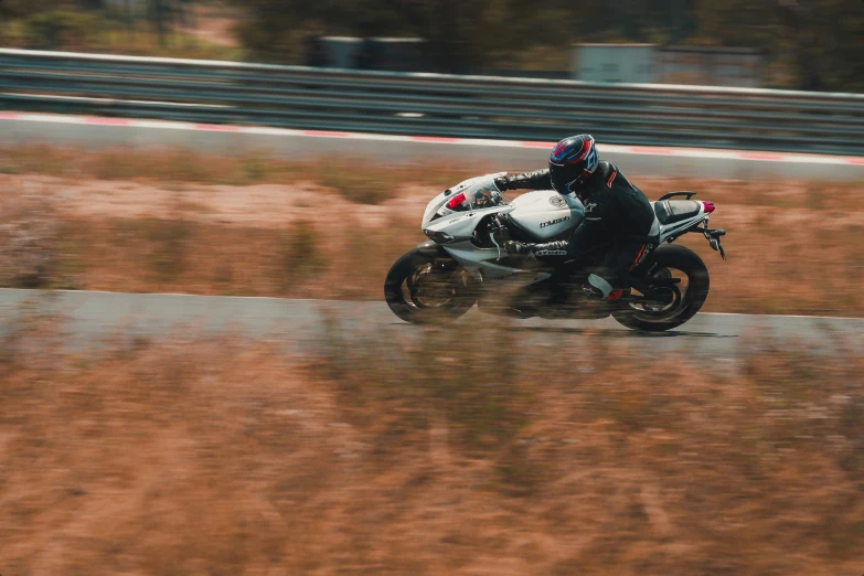 a man on a motorcycle rides down a long street