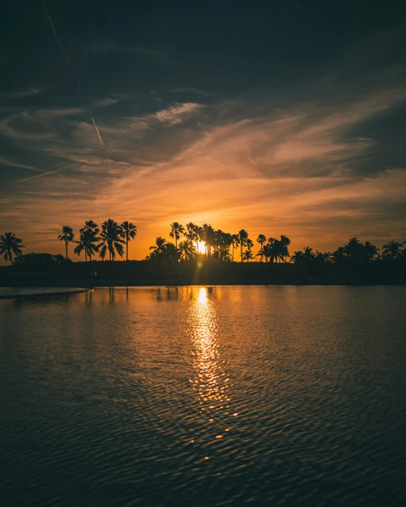 the sun shining through the clouds over a body of water