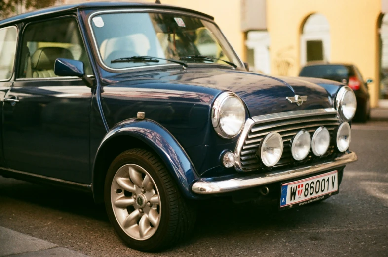 a small blue car parked on the side of the road