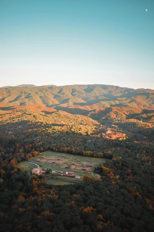 an aerial view of a grassy area surrounded by mountains